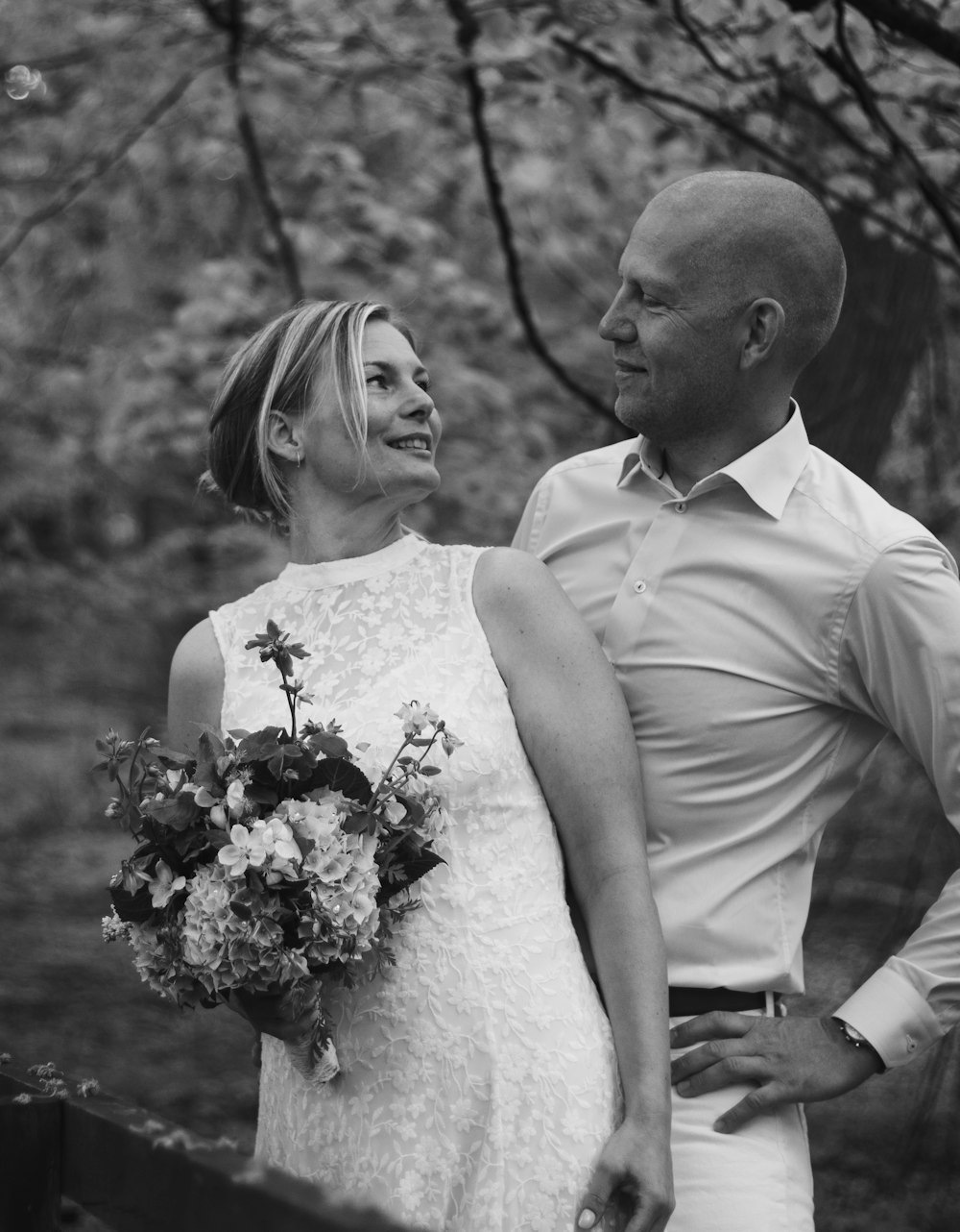 man and woman standing beside trees