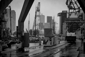 Black and white image of a shipping dock at dawn, emphasizing the industrial backbone of our work.