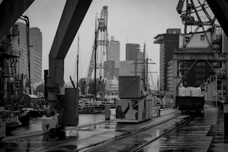 Black and white image of a shipping dock at dawn, emphasizing the industrial backbone of our work.