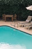 two gray sunbathing loungers beside pool