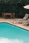 two gray sunbathing loungers beside pool