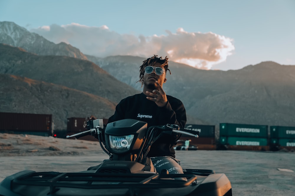 man wearing black sweater riding ATV during cloudy day