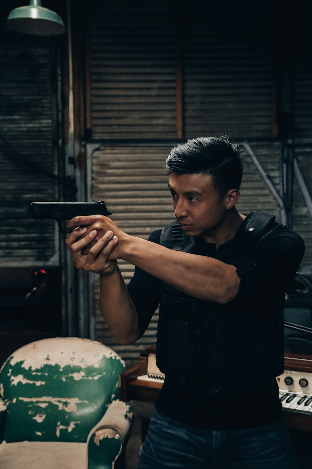 man holding pistol wearing black bulletproof vest