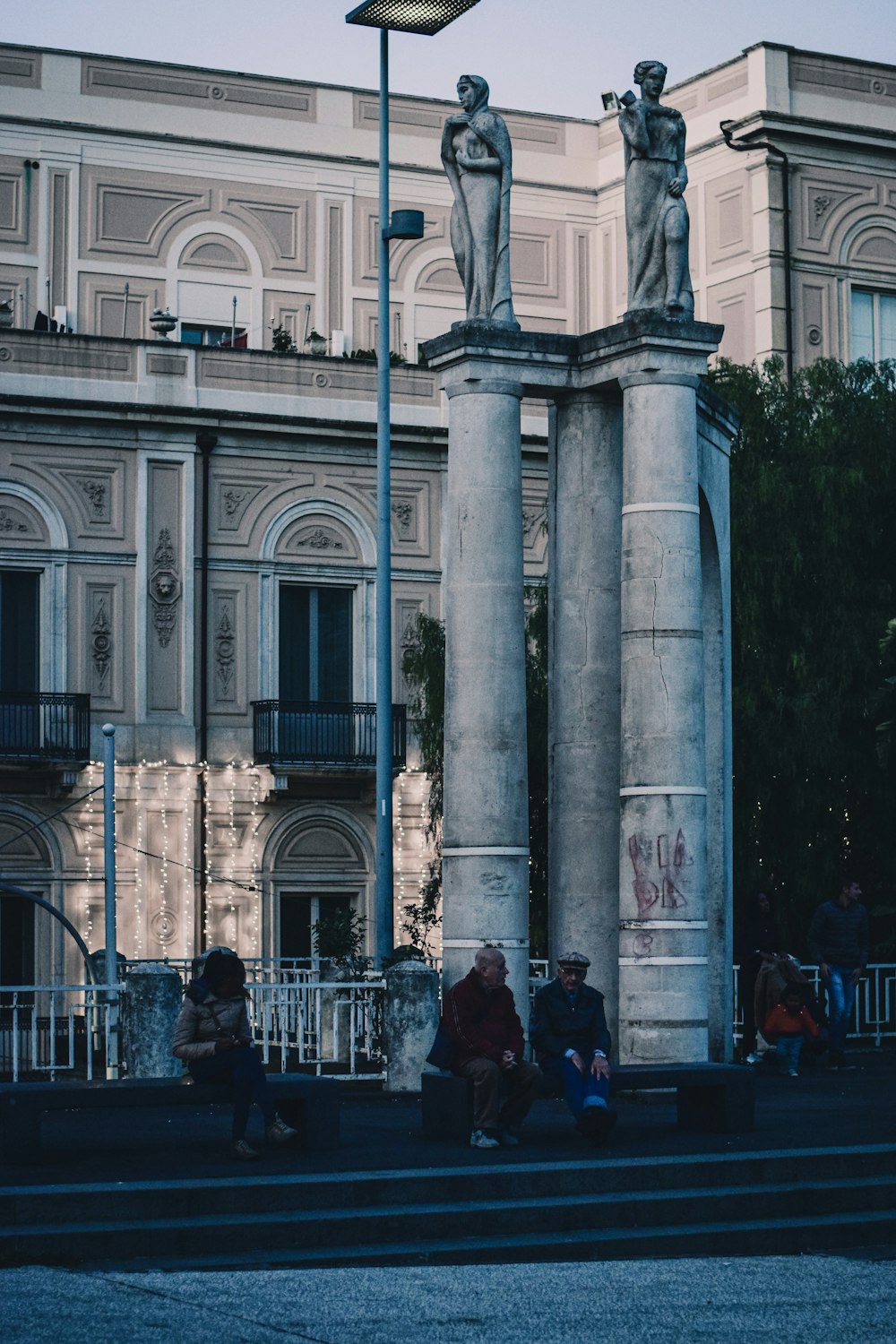 people sitting on stairs near building during daytime