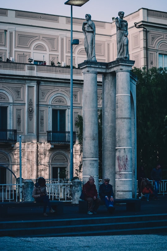 people sitting on stairs near building during daytime in Catania Italy