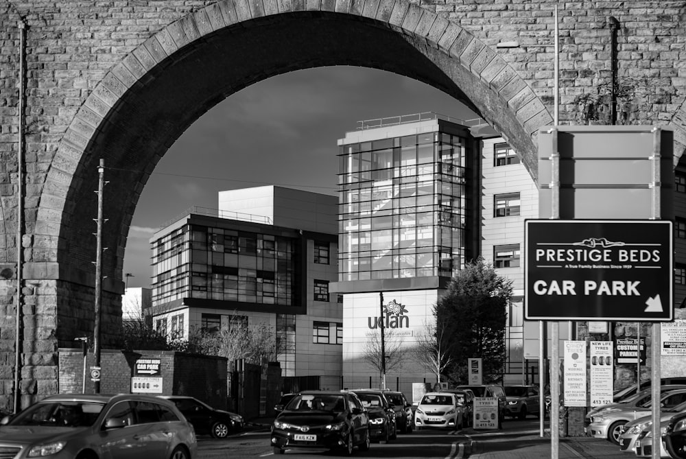 Photographie en niveaux de gris d’une voiture sur les routes