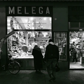 A dimly lit butcher shop storefront, bathed in shadows with vivid red accents illuminating the windows.