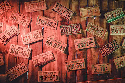 A collection of patriotic license plate frames arranged on a rustic wooden table, highlighting variety and quality.