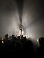 An audience captivated by a powerful performance, with soft spotlight illuminating the stage.