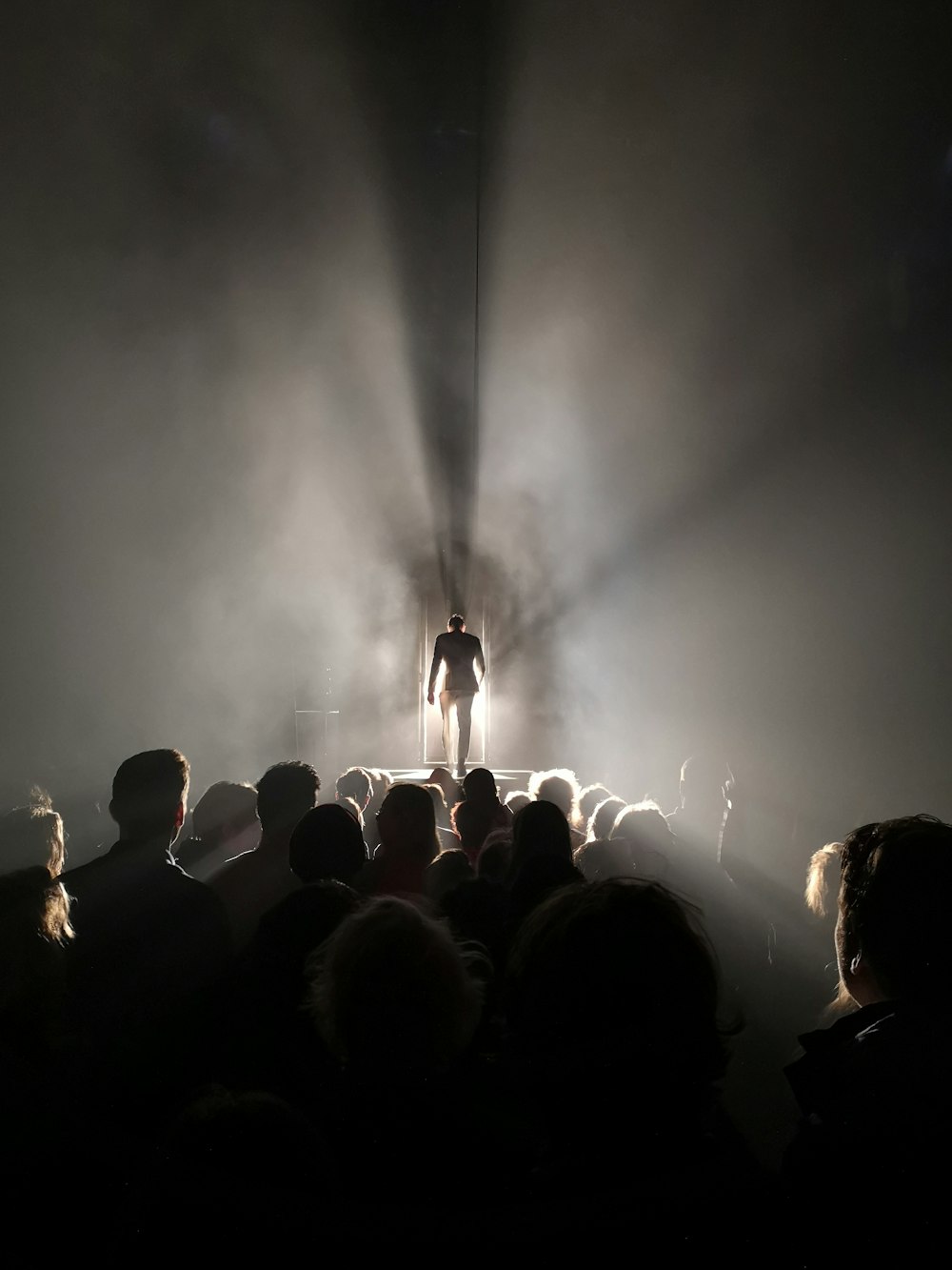 people looking on man standing on stage