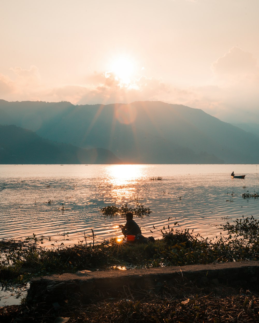 a person sitting on the edge of a body of water