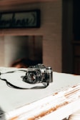 A close-up of a vintage film camera on a table.