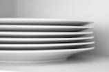 A set of abstract-designed plates stacked neatly with soft natural light.