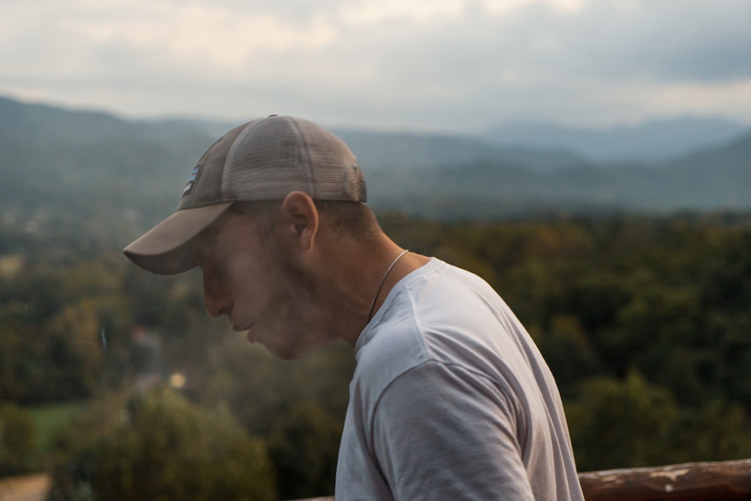 man wearing gray crew-neck shirt and brown cap