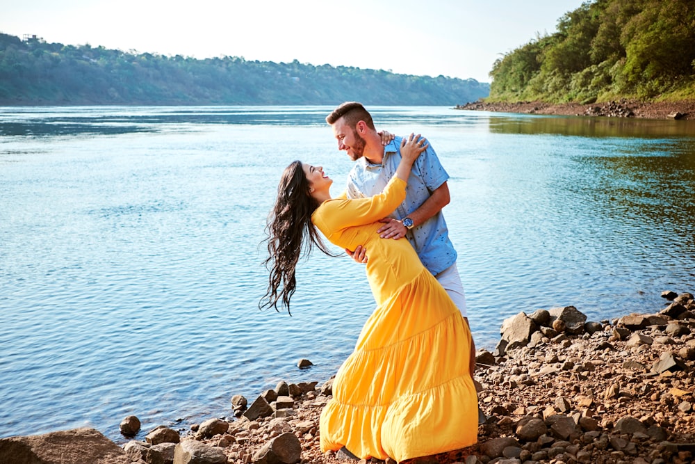 man and woman dancing beside body of water