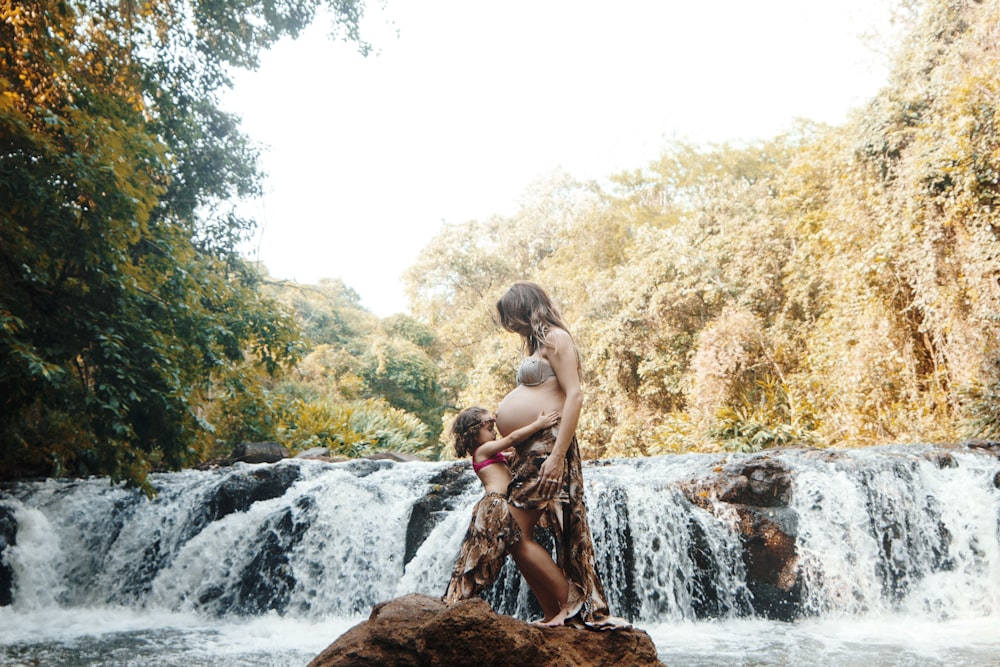 toddler hugging pregnant woman outdoors