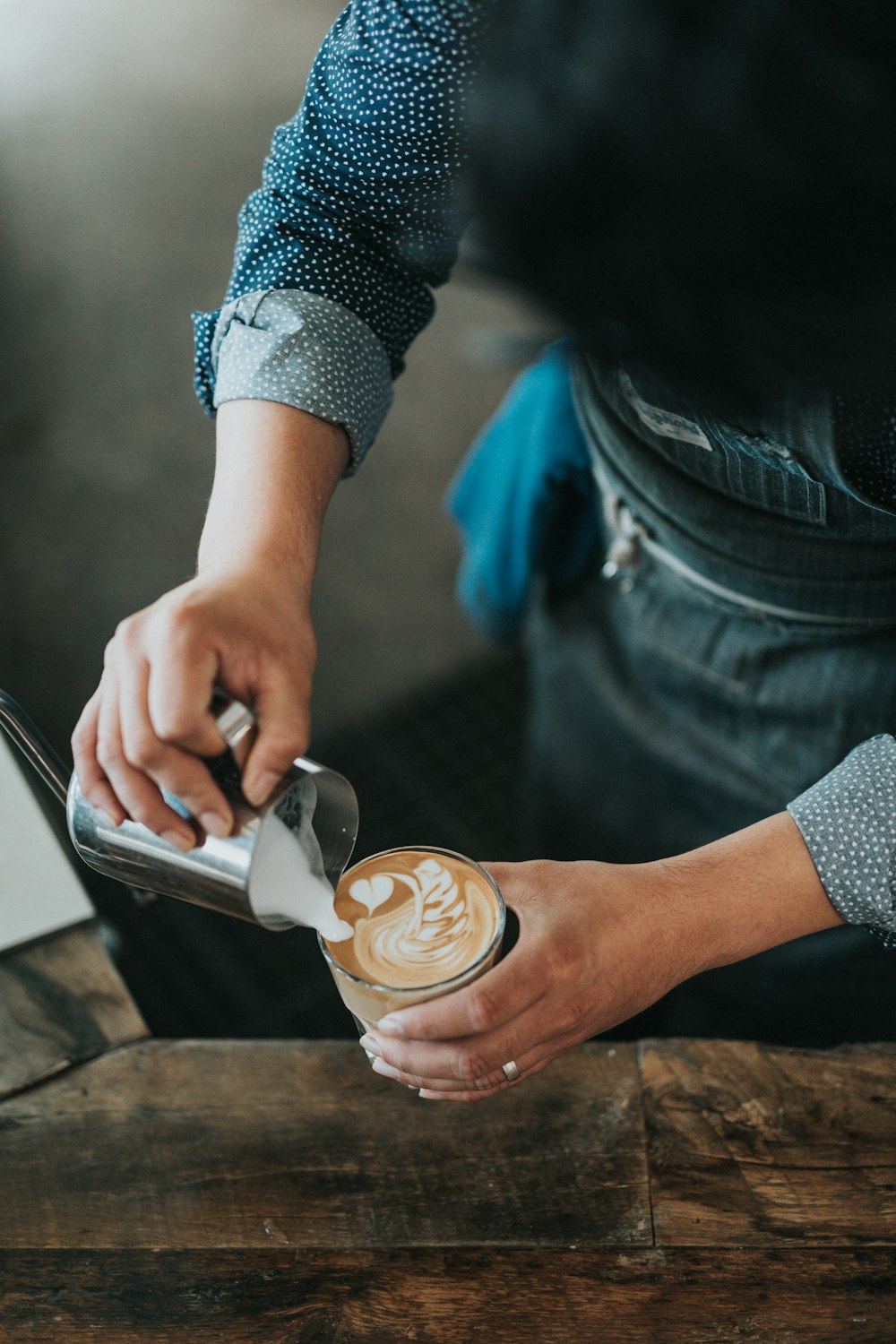 man pouring cream on coffee