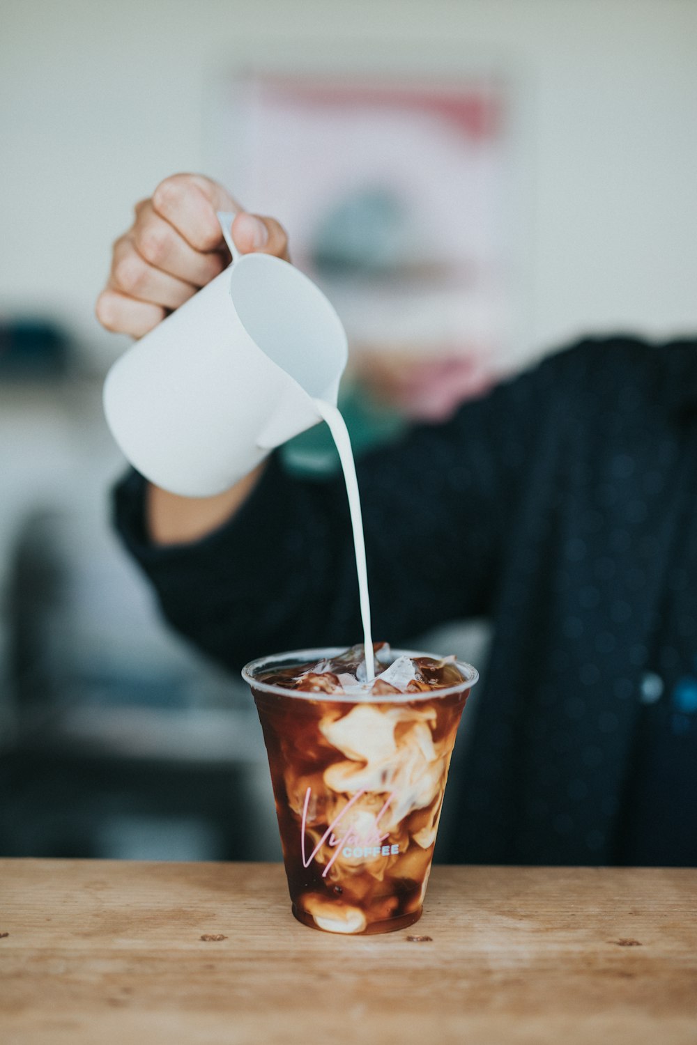 persona vertiendo crema en la taza