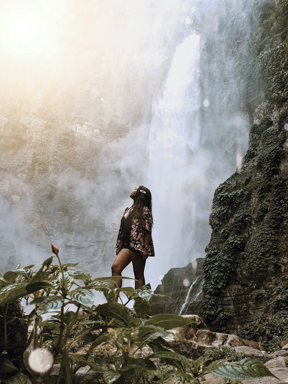 woman looking up at waterfalls
