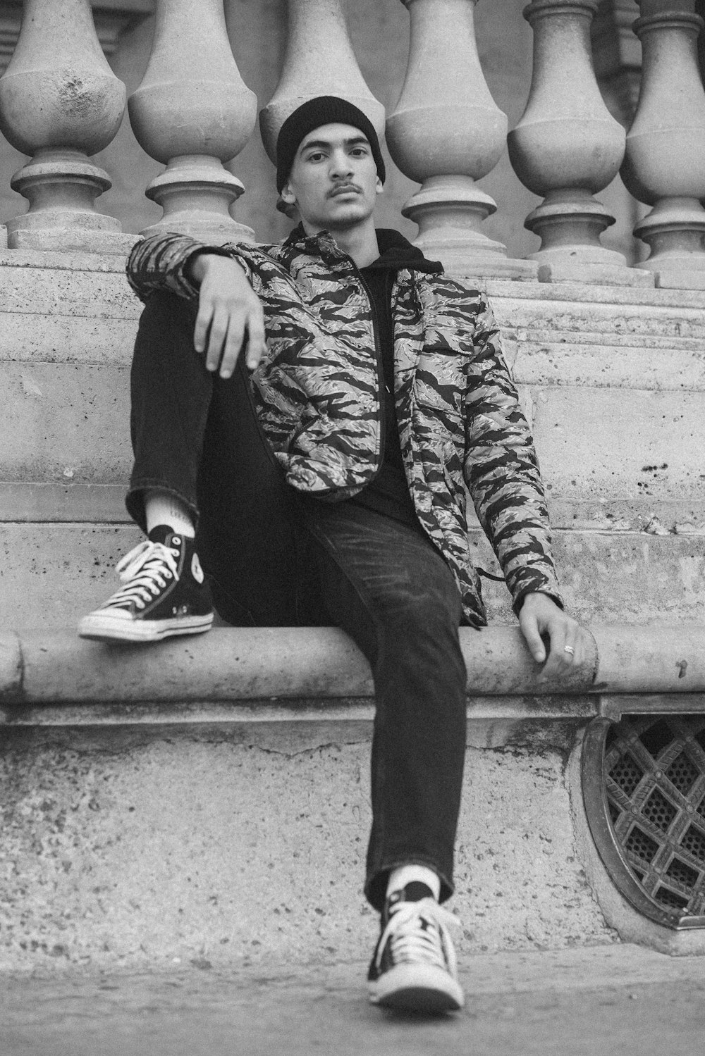 Photo en niveaux de gris d’un homme assis sur un banc