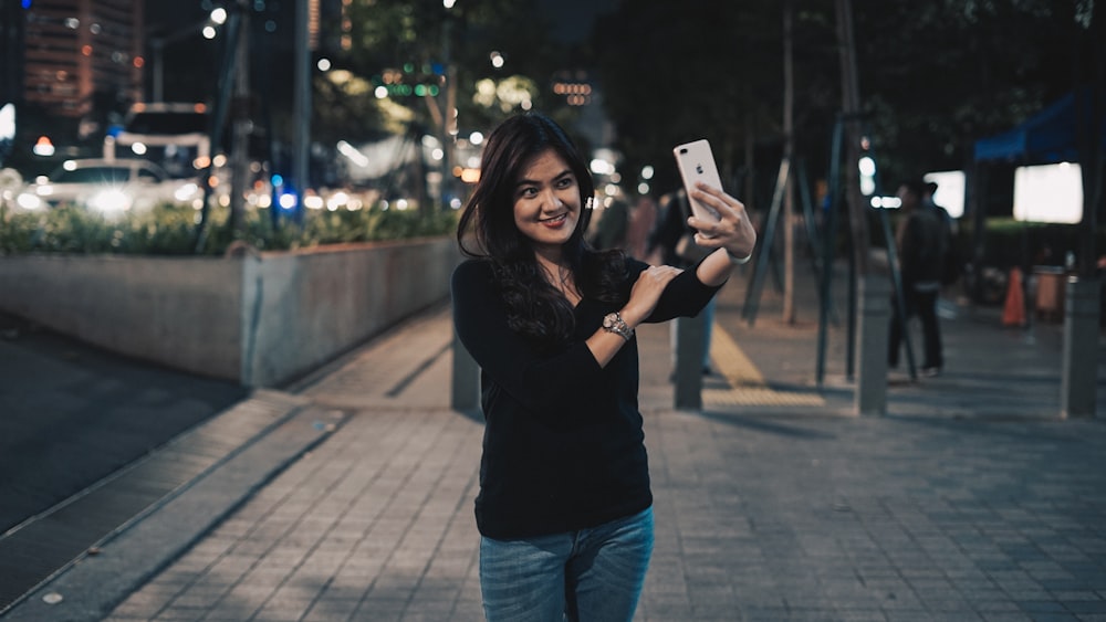 mujer tomando selfie cerca del aire libre durante la noche
