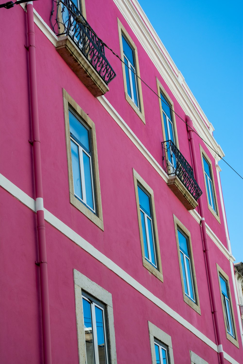 발코니와 발코니에 발코니가있는 분홍색 건물
