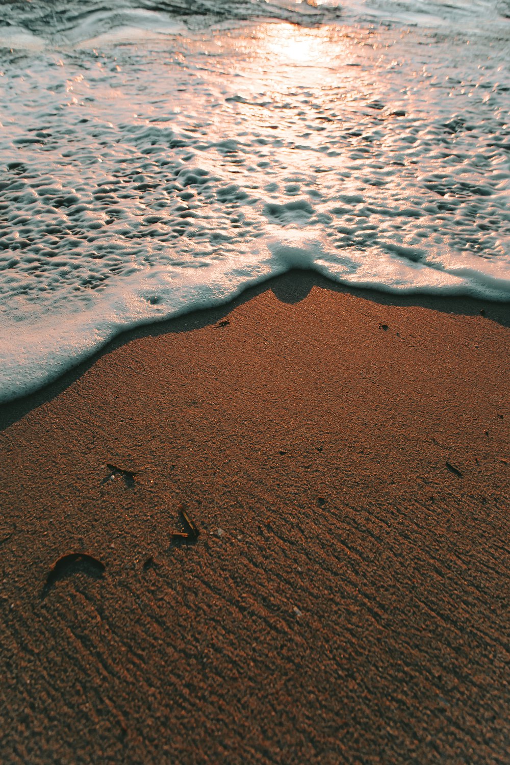 a sandy beach with waves coming in to shore