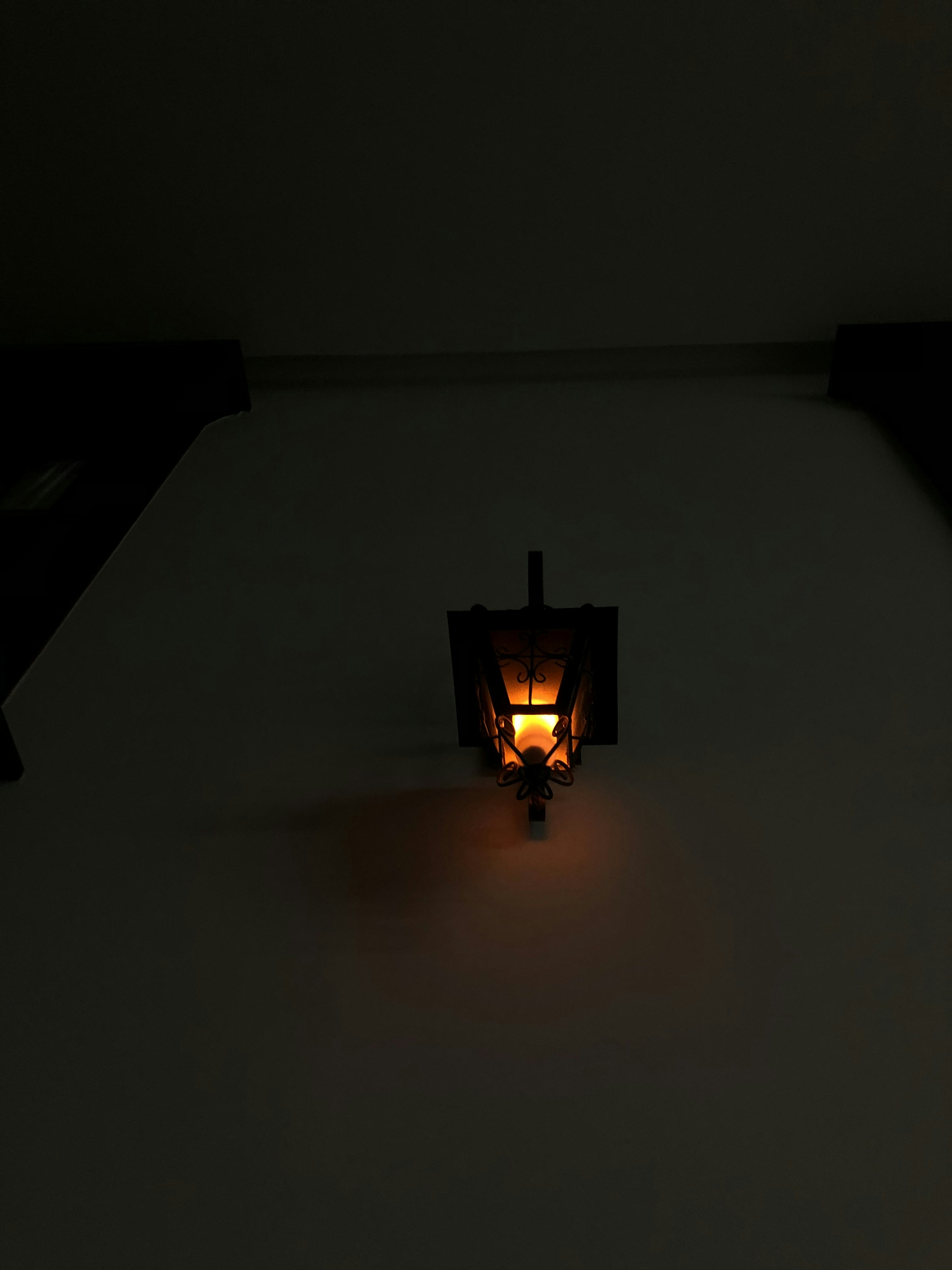 Ornate brass oriental lanterns glowing in warm amber light against dark wall