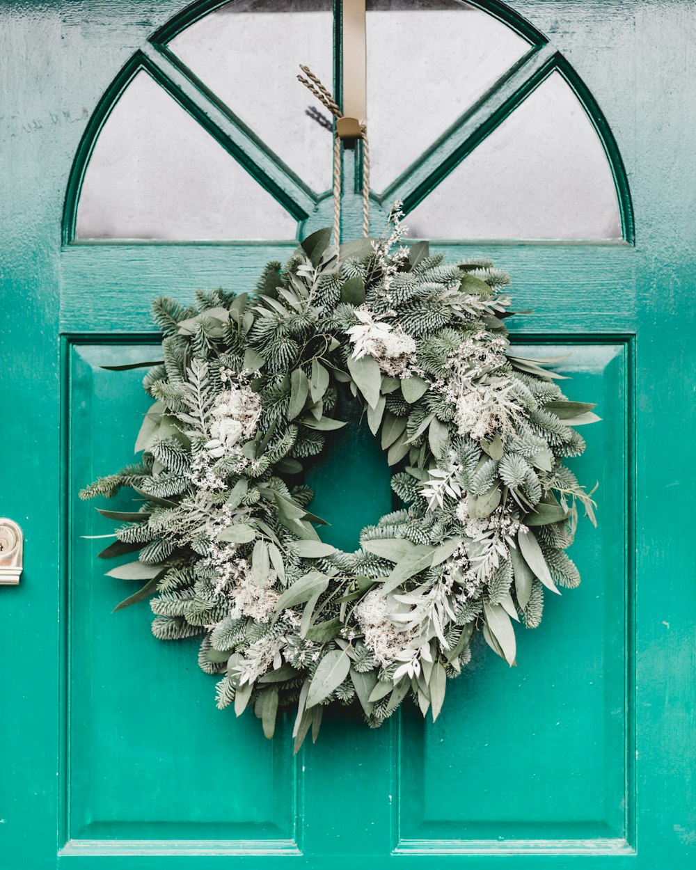 green leafy wreath hanging on door