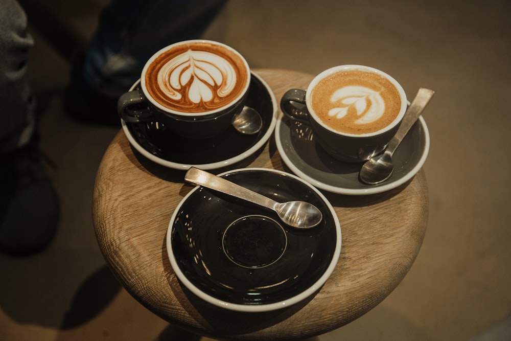 two cups of latte on round brown stool