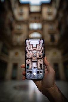 shallow focus photography unknown person holding black smartphone