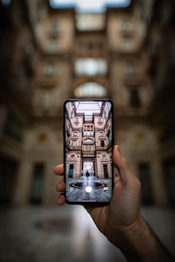 shallow focus photography unknown person holding black smartphone