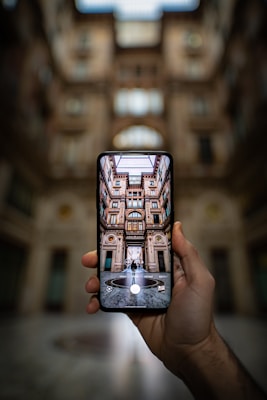 shallow focus photography unknown person holding black smartphone