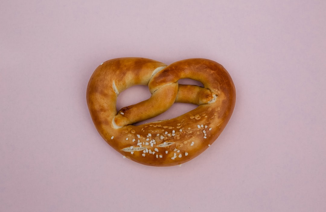 bread knot on pink surface, Typical stereotyp Bavaria specialty Brezel pretzel