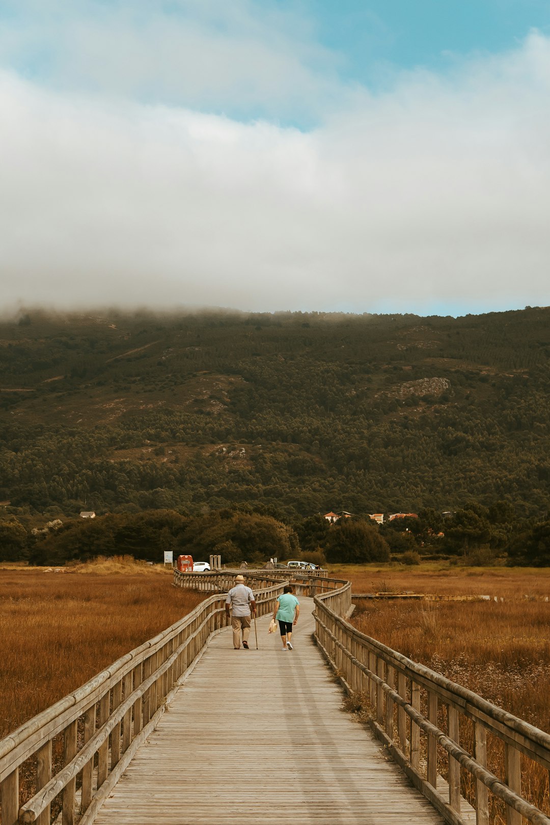 two person walking on beige bridge during daytime