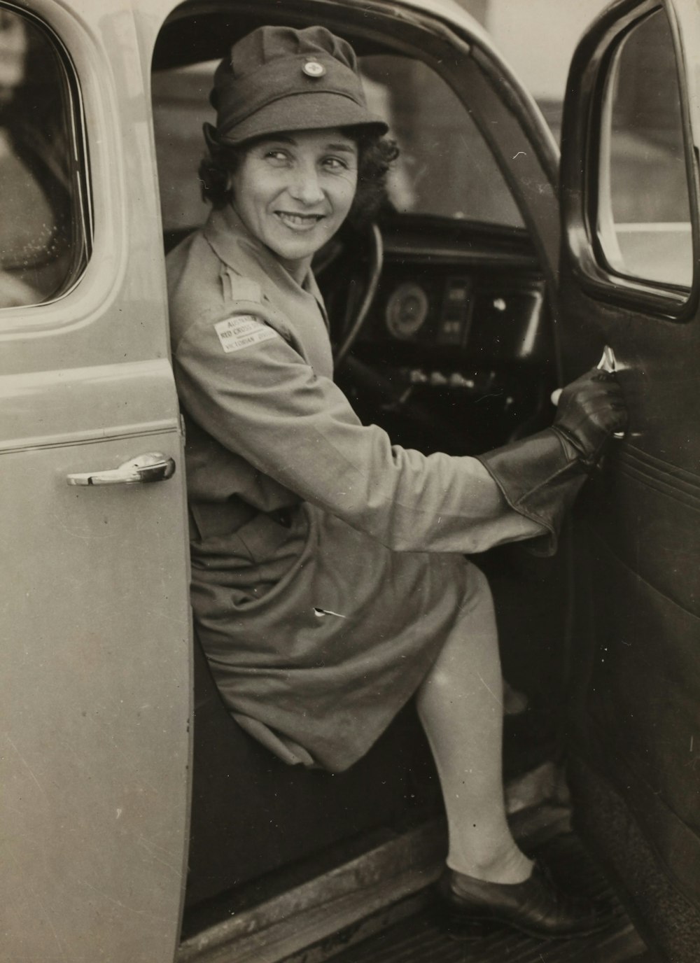 a black and white photo of a woman sitting in a car