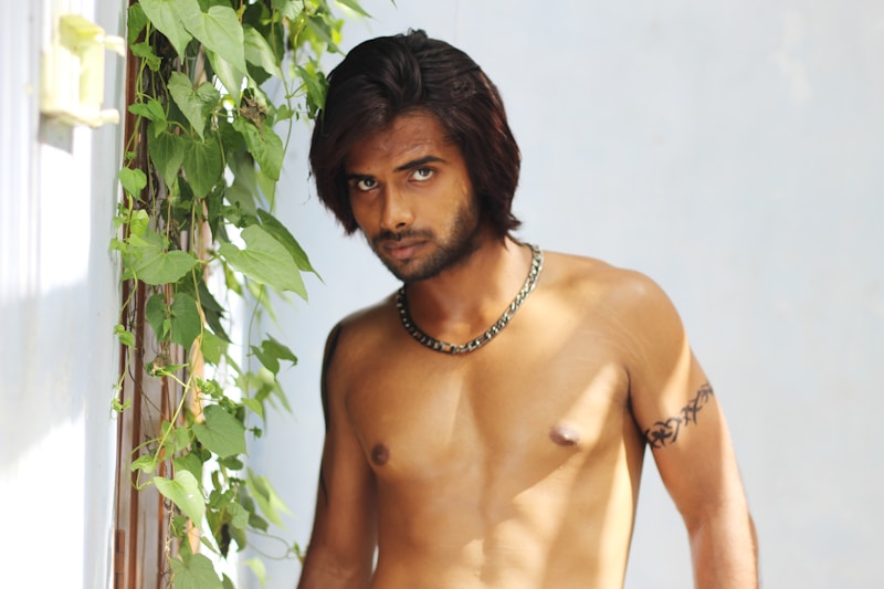 Shirtless man posing with plant