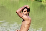 topless man on body of water