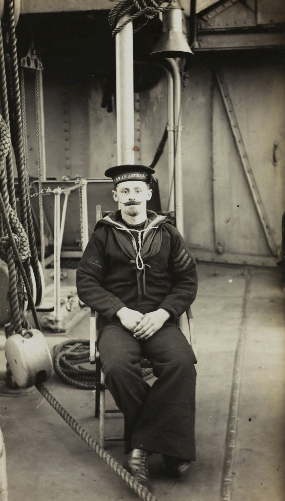 grayscale photography of man sitting on chiar