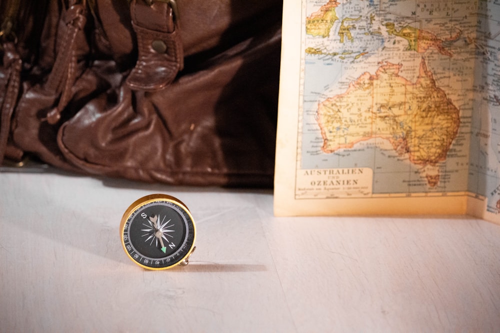 gold and black compass near map chart