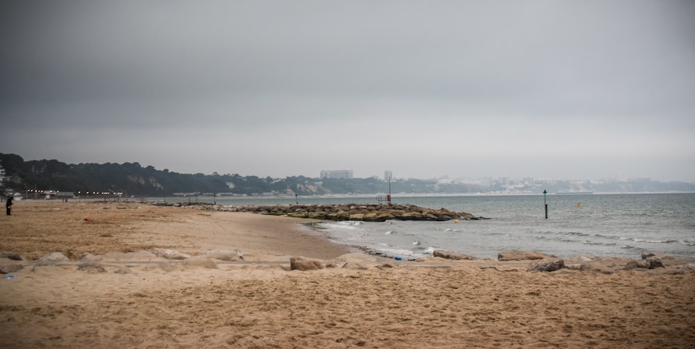 a sandy beach next to a body of water