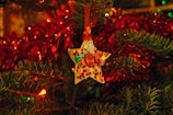 Brightly colored star-shaped decorations made from sustainable materials glowing softly on a Christmas tree.