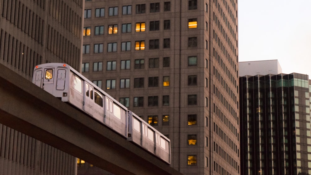 Tren blanco que viaja cerca de edificios