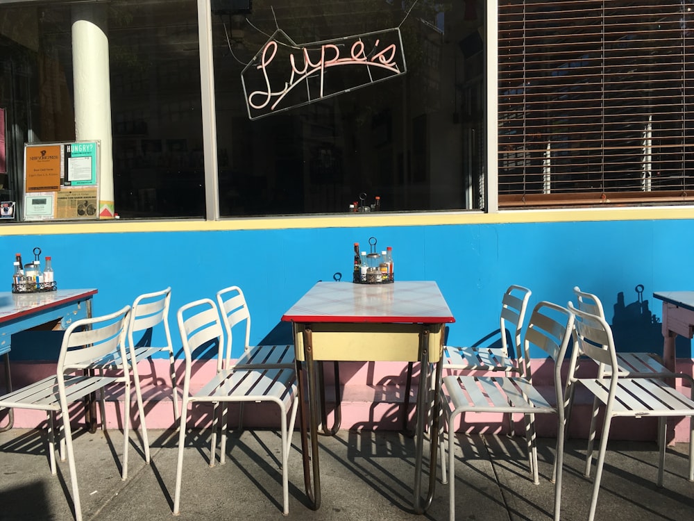 square white table with chairs beside wall