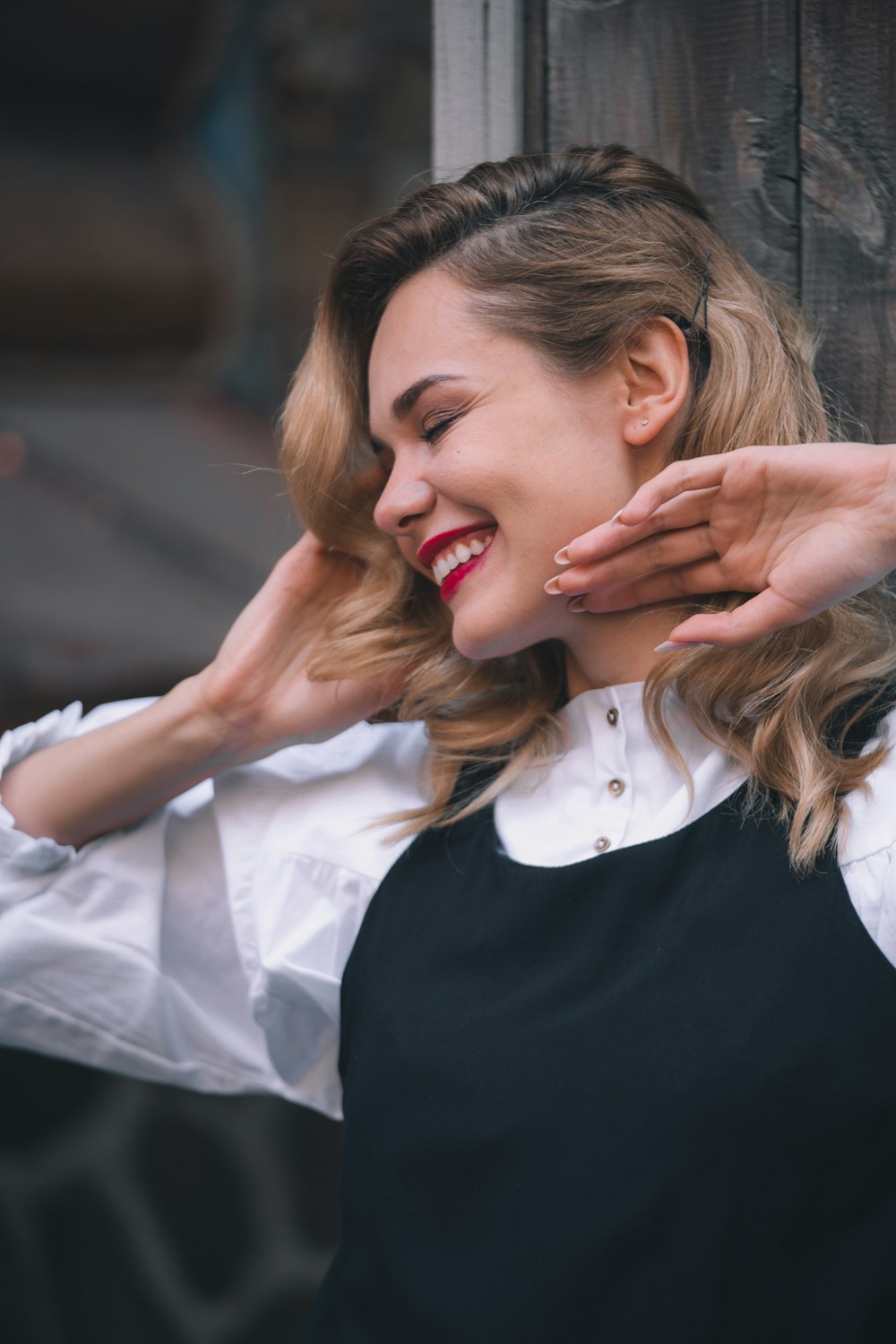 woman smiling beside wall