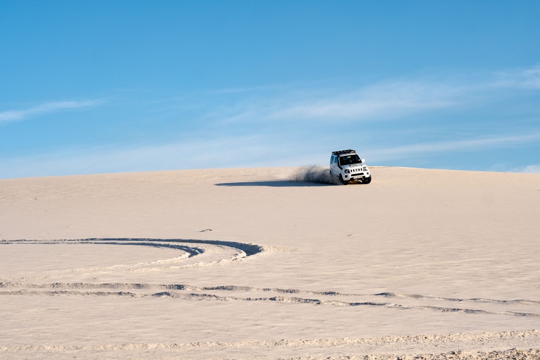 white SUV driving on a desert, Car driving on sand dunes