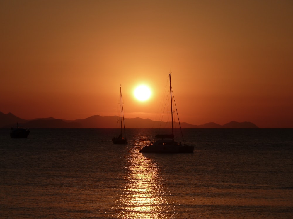 two boats sailing during sunrise