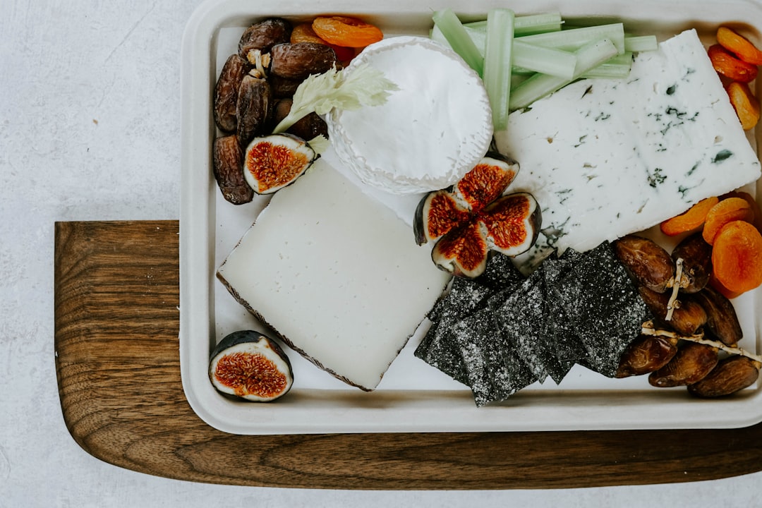 sliced fig fruit, white cheese, nuts, and yogurt on tray