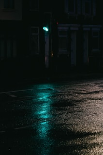 A cinematic still of a moody urban night scene with deep shadows and green highlights.