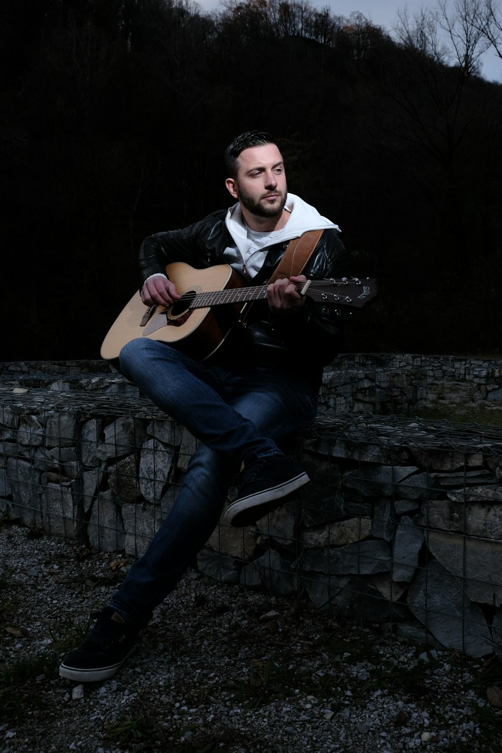 man playing brown acoustic guitar